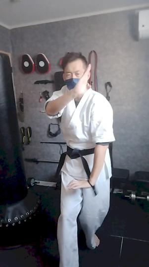 空手道場内で尾鱗の構えを取る不動館の実戦護身構え
