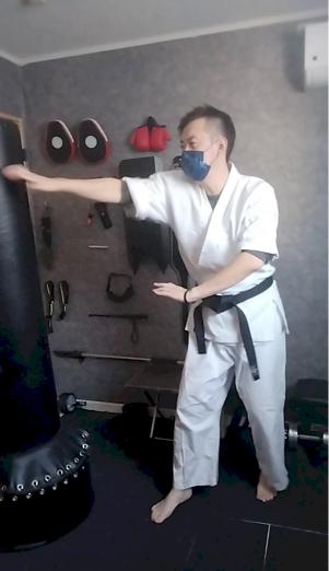 空手道場内で尾鱗の構えを取る不動館の実戦護身構え
